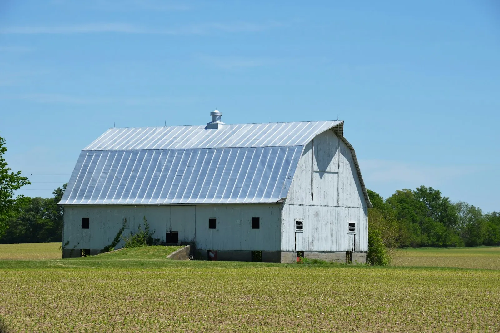 A post-frame building with a metal roof in an open field